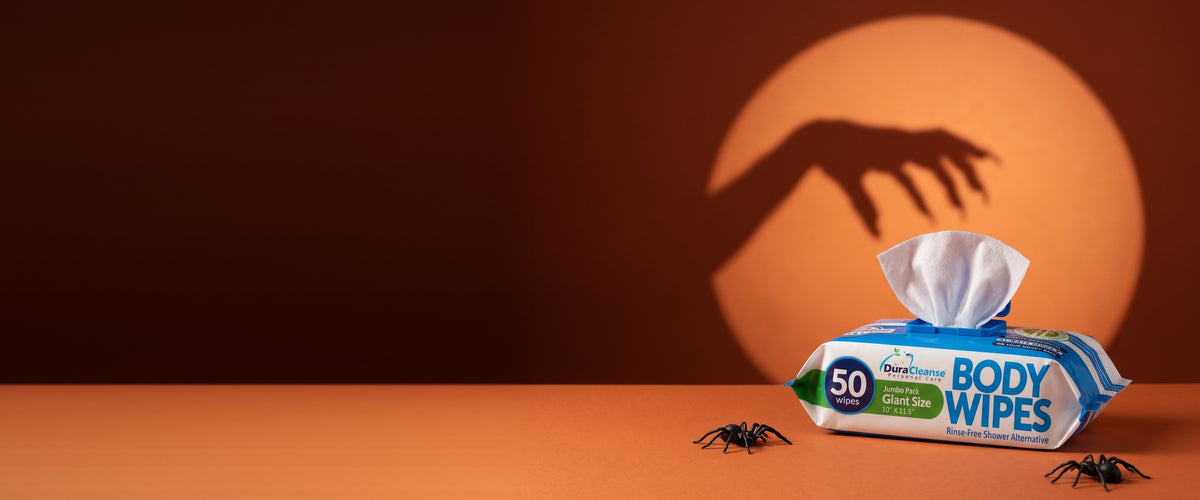 Shadow of a hand reaching for a pack of Dura Cleanse body wipes under an orange spotlight